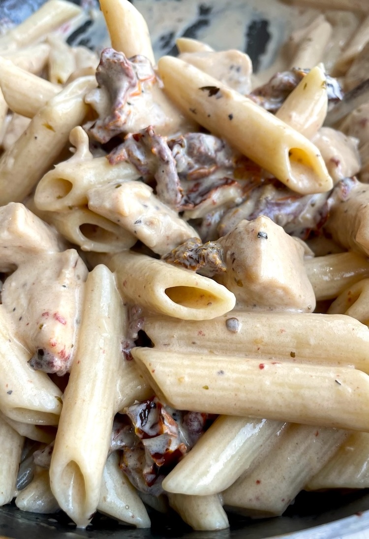 Close up view of a delicious and easy chicken pasta made with a creamy sun dried tomato sauce. 