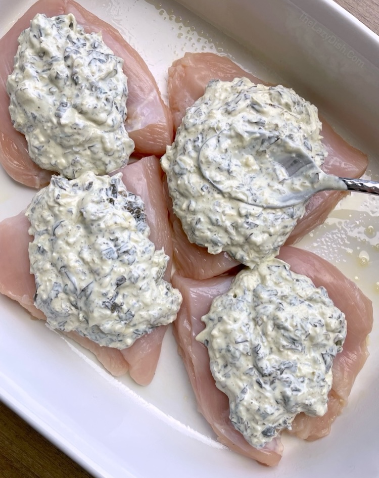 The easiest chicken dinner recipe! Just top few chicken breasts with store bought spinach artichoke dip and lots of gooey shredded cheese. Bake and dinner is done!