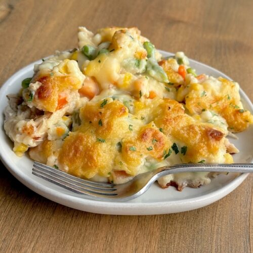 An easy chicken dinner casserole made with red lobster cheddar bay biscuit mix, rotisserie chicken, frozen veggies, chicken broth, soup, and milk. An amazing comfort food recipe for a large family with kids.