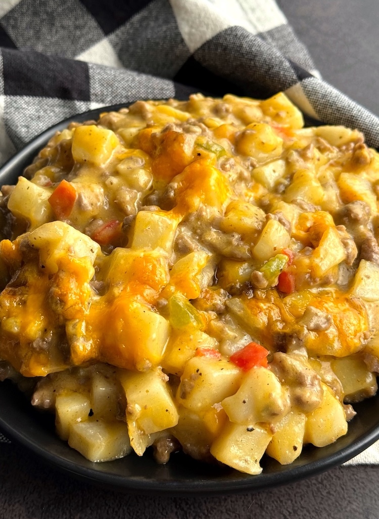 Cheesy Ground Beef & Potato Dinner Casserole on a plate ready to eat for dinner! A tasty family meal for the pickiest of eaters. 