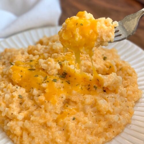 Quick and easy vegetable side dish for dinner made with frozen cauliflower rice, cream cheese, butter, cheddar, milk, and seasoning.