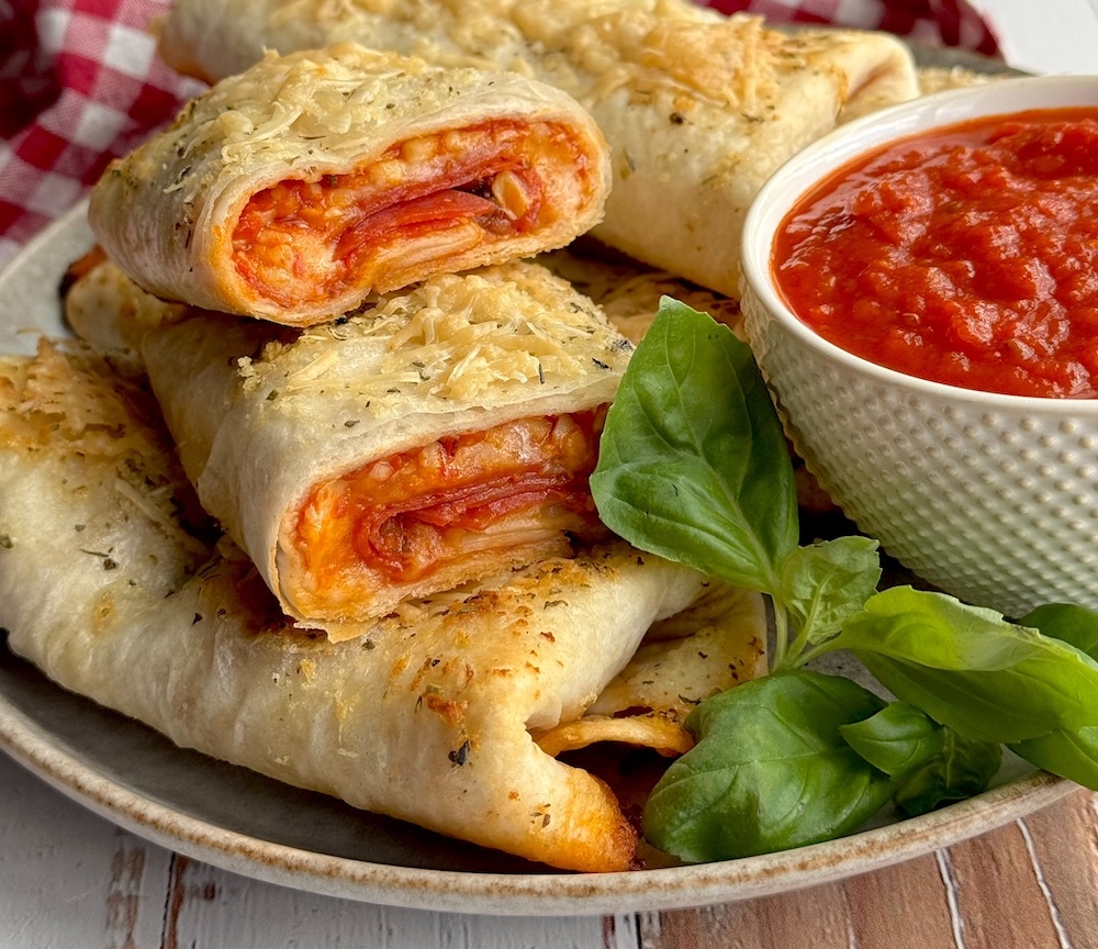 Oven Baked Pizza Burritos loaded with all of your favorite pizza toppings like pepperoni! This fun and easy weeknight meal is kid friendly, cheap to make, and totally delicious.