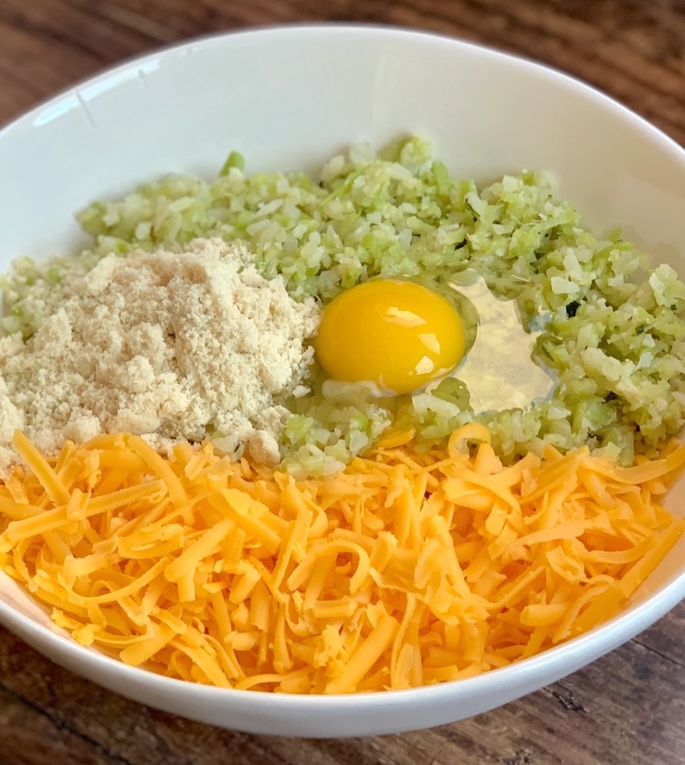 List of ingredients needed to make the best crispy broccoli cheese bites in the oven: frozen broccoli or cauliflower rice, egg, cheddar cheese, seasoning, and flour. 