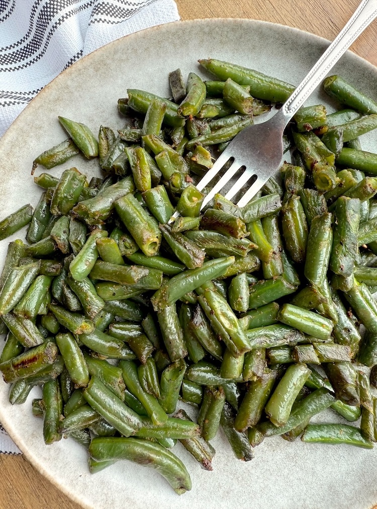 Cooked frozen green beans on a plate ready to eat. 