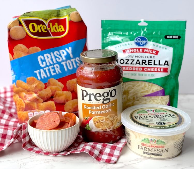 Ingredients for an easy pizza tater tot casserole including frozen tater tots, pepperoni, mozzarella cheese, parmesan, and pasta sauce. 